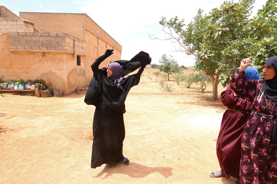 Une femme retire son niqab qu'elle portait après que les Forces démocratiques syriennes ont chassé les dihadistes de Daesh.