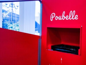 Une poubelle invisible est accrochée au mur de la cabine.