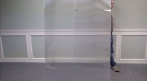 Un homme quasi invisible en passant derrière une plaque transparente