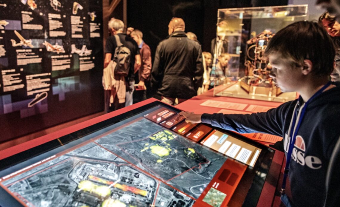 Garçon qui teste les écrans de contrôle de l’exposition espions