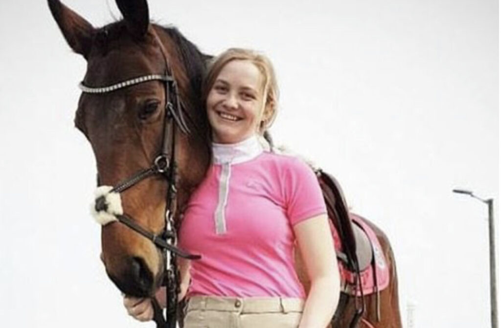 Pia, souriante, accompagné de son cheval quan,d celui ci était vivant 